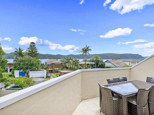 a patio with a table and chairs on a balcony at The Lookout at Iluka Resort Apartments in Palm Beach