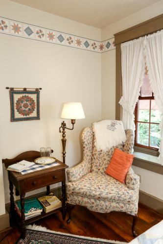 a bedroom with a chair and a table and a window at Deer Creek Winery at Watson Estate in Uniontown