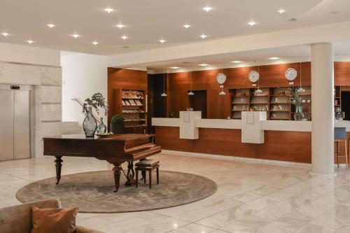 a lobby with a piano in a library at Hotel am Vitalpark in Heilbad Heiligenstadt