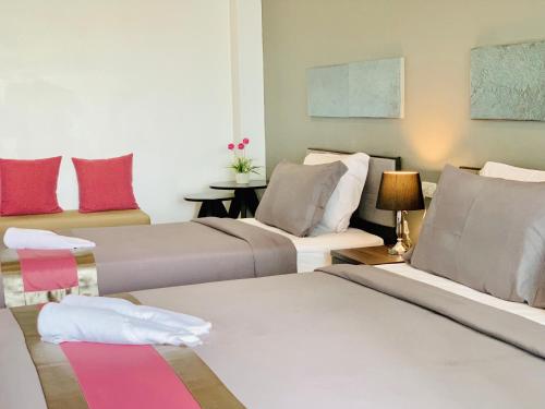 two beds in a room with red and white at Tandeaw View in Hua Hin