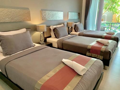 um quarto de hotel com três camas num quarto em Tandeaw View em Hua Hin