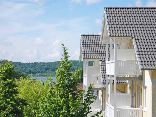 - un bâtiment avec des balcons blancs et une vue sur le lac dans l'établissement Wohnpark Stadt Hamburg in Binz - WG 57, à Binz