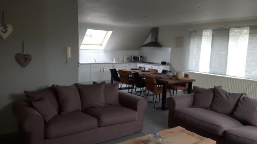 a living room with a couch and a table and a kitchen at Hemelse Helderheid in Maasmechelen