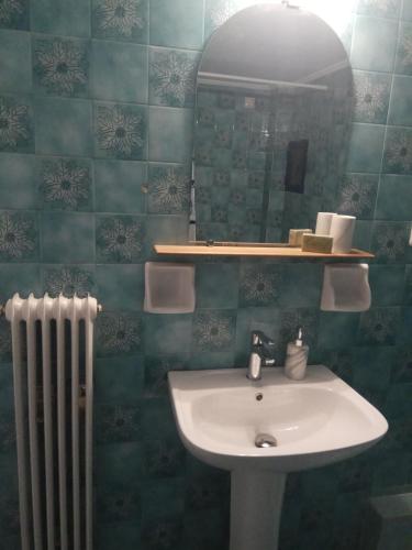 a bathroom with a sink and a mirror and a radiator at Central Mark-Δωμάτια Διαμερίσματος in Volos