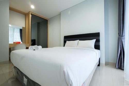 Postel nebo postele na pokoji v ubytování Well Furnished 1BR Brooklyn Alam Sutera Apartment By Travelio