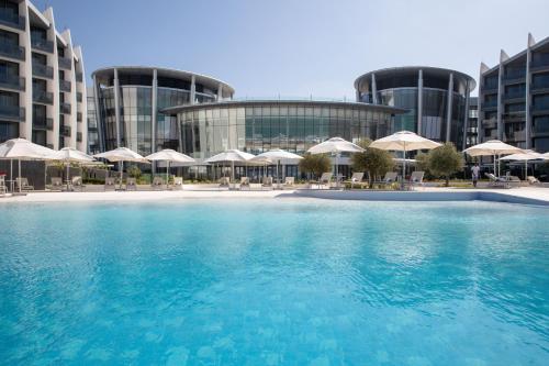 a hotel room with a pool and beach at Jumeirah at Saadiyat Island Resort in Abu Dhabi