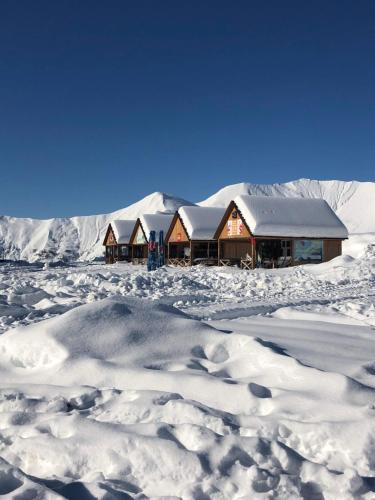 una baita nella neve con un mucchio di neve di Ski Heaven a Gudauri