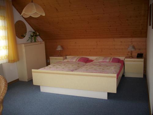 a bedroom with a large bed in a wooden room at Steffens in Soltau