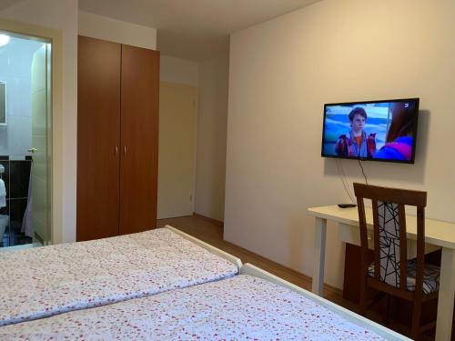 a bedroom with a bed and a television on the wall at Vinarija Zlatar in Zlatar