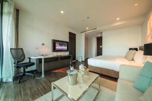 a hotel room with a bed and a desk at Civic Horizon Hotel & Residence in Bangkok