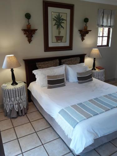 a bedroom with a large white bed with two lamps at Joan's Bed and Breakfast in Durban