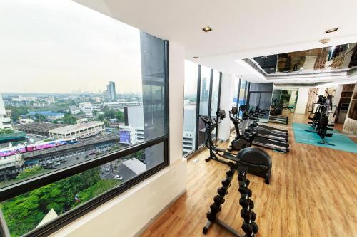 a gym with treadmills and ellipticals in a building at Civic Horizon Hotel & Residence in Bangkok