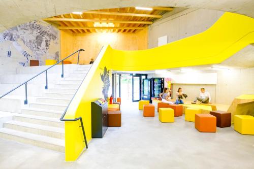 a yellow staircase in an office with people sitting in chairs at Jugendherberge Bayreuth in Bayreuth