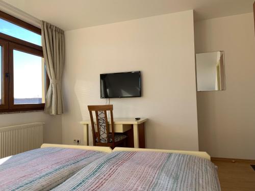 a bedroom with a bed and a tv on the wall at Vinarija Zlatar in Zlatar