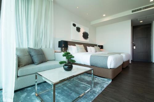 a hotel room with a bed and a couch at Civic Horizon Hotel & Residence in Bangkok
