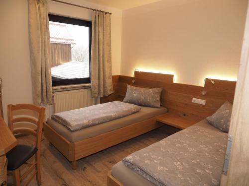 a small room with two beds and a window at Birkholmhof in Bärnau