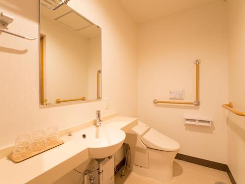 a bathroom with a sink and a toilet and a mirror at Sun Green Resort Hotel Ishigaki in Ishigaki Island