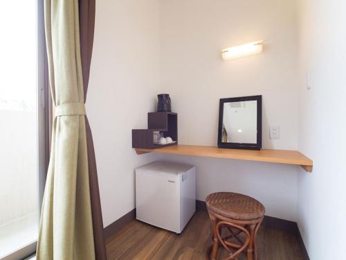 a room with a mirror and a stool and a shelf at Sun Green Resort Hotel Ishigaki in Ishigaki Island