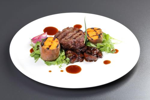 a plate of food with meat and vegetables on a table at Active Hotel in Wrocław