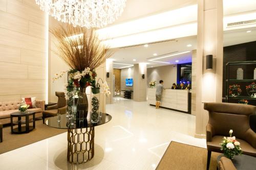a lobby with a table with flowers on it at Civic Horizon Hotel & Residence in Bangkok