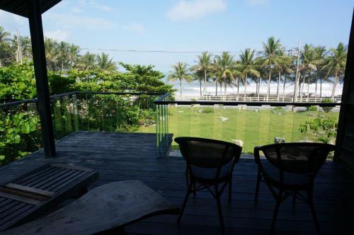 a porch with two chairs and a view of the beach at Coconut Beach Homestay in Beinan