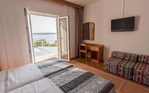 a hotel room with a bed and a balcony at Hotel Barba in Starigrad