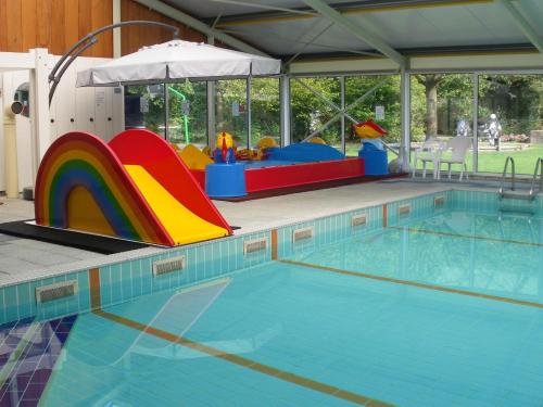 a large swimming pool with a playground and a slide at Vakantieoord De Bronzen Emmer in Meppen