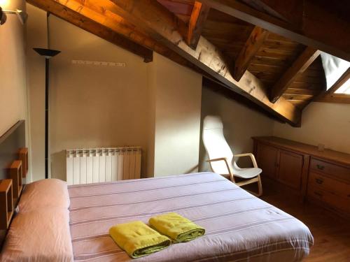 1 dormitorio con 1 cama con 2 toallas amarillas en Casa Puigcerda en Puigcerdá