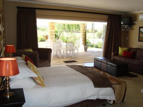 a bedroom with a large bed and a living room at Orangia Game Lodge in Aliwal North