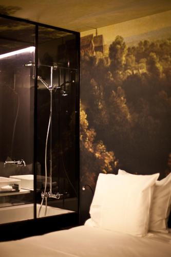 a bedroom with a bed with a painting on the wall at HotelO Kathedral in Antwerp