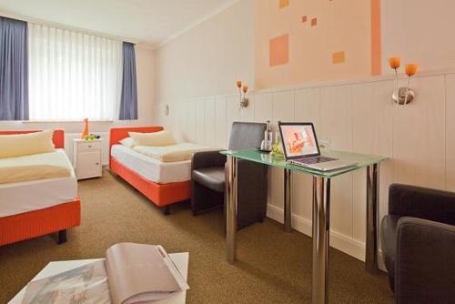 a hotel room with a desk with a laptop on it at Kocks Hotel Garni in Hamburg