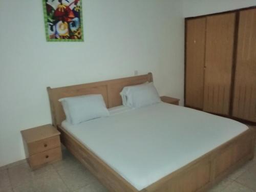 1 dormitorio con 1 cama con cabecero de madera en PANAASA GUEST HOUSE, en Oko Sombo