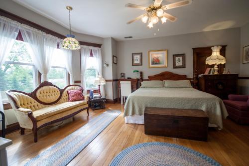 a bedroom with a bed and a couch and windows at Friendly City Inn B&B in Harrisonburg