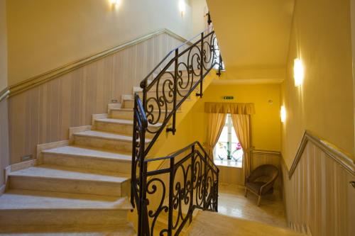 a staircase in a home with yellow walls at Barokk Hotel Promenád in Győr