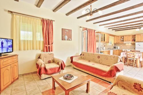 a living room with a couch and a tv at Bella Villa Vasiliki in Litherés