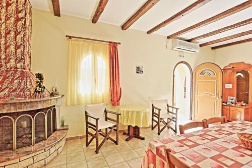 a bedroom with a fireplace and a table and chairs at Bella Villa Vasiliki in Litherés
