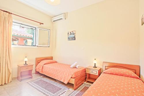 a bedroom with two beds and a window at Bella Villa Vasiliki in Litherés