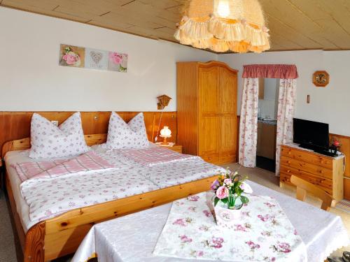 Un dormitorio con una gran cama de madera con flores. en Ferienhaus Wurzelbergblick, en Masserberg