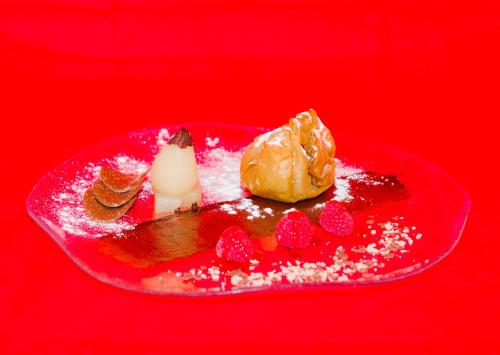 a red plate with a dessert on a red background at Hotel Rural La Dehesilla in Barajas de Gredos