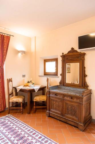 a room with a table and a dresser with a mirror at Villa La Malva in Poggio alla Malva