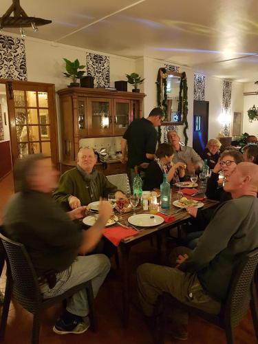 a group of people sitting around a table eating at La Châtaigneraie in Uzer