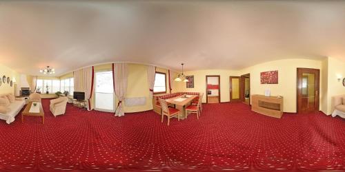 a living room with a red carpet at Ferienhotel Gasthof zur Post in Untertauern