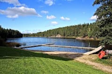 a lake with a dock on the side of it at Rinkeby Gård in Jönåker