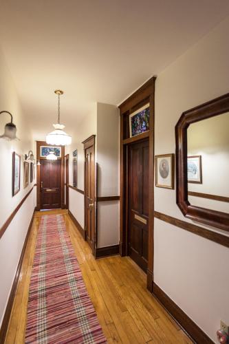a hallway with wooden floors and doors and a rug at Friendly City Inn B&B in Harrisonburg