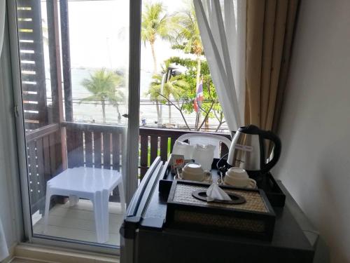 a tea maker on a table in front of a balcony at MONTANA COURT PATTAYA in Pattaya Central