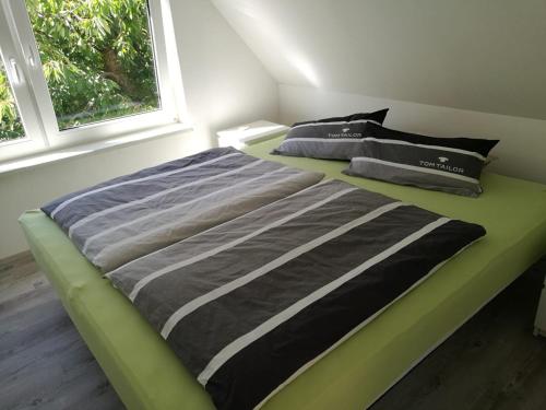 uma cama verde num quarto com uma janela em Ferienhaus Görmer mit Wasserbett em Schmölln