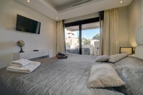 1 dormitorio con 1 cama grande y ventana grande en Luxury Penthouse with private pool (Bdlp15b), en Estepona