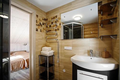a bathroom with a sink and a shower and a bed at Vila "Laumių lankos" in Plateliai