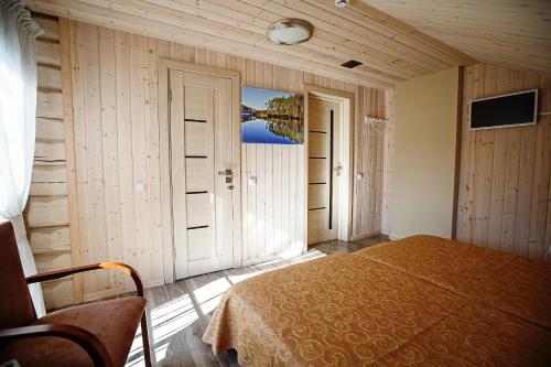 a bedroom with a bed in a room with wooden walls at Vila "Laumių lankos" in Plateliai