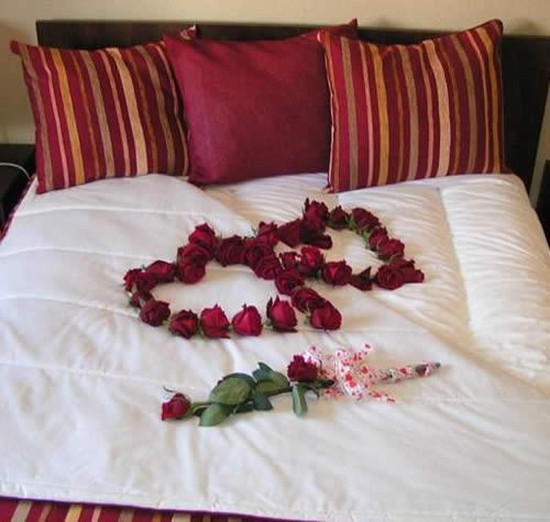 a heart made out of roses on a bed at seiaalojamentos in Seia